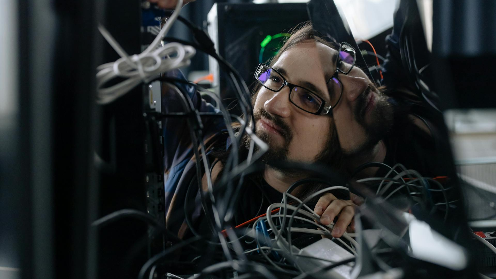 IT technician organizing cables at a workstation in a small business office