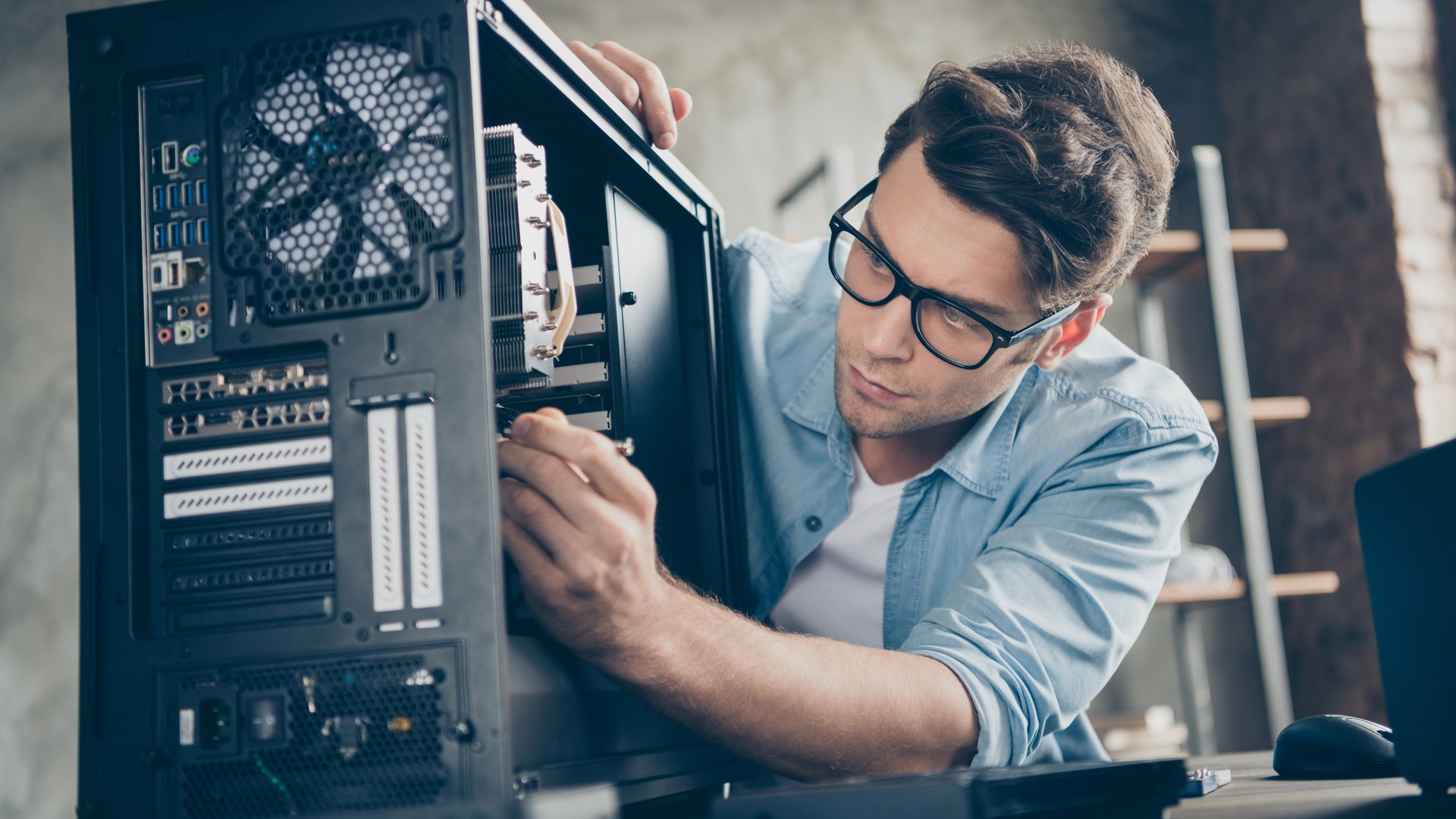 Technician repairing desktop computer hardware for break-fix IT support