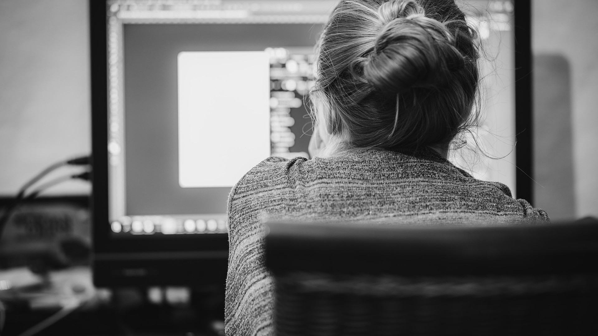 IT professional working across multiple desktop monitors