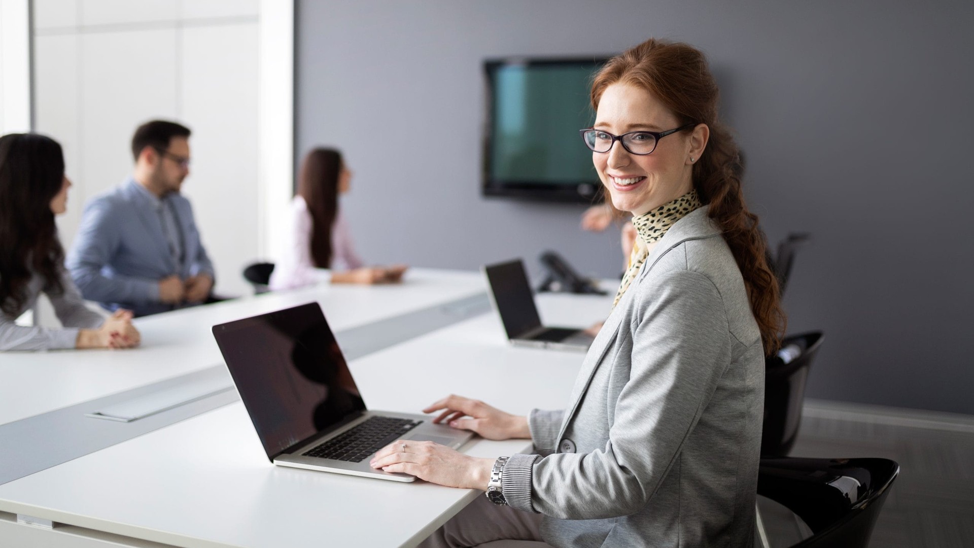 Employees in a conference room with laptops for cybersecurity training