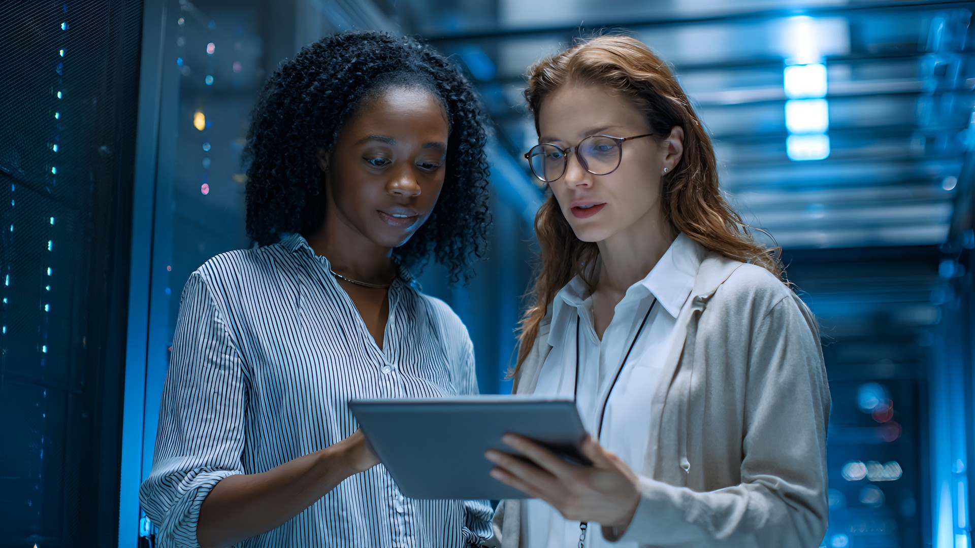 Cloud engineers reviewing infrastructure on a tablet in a data center office