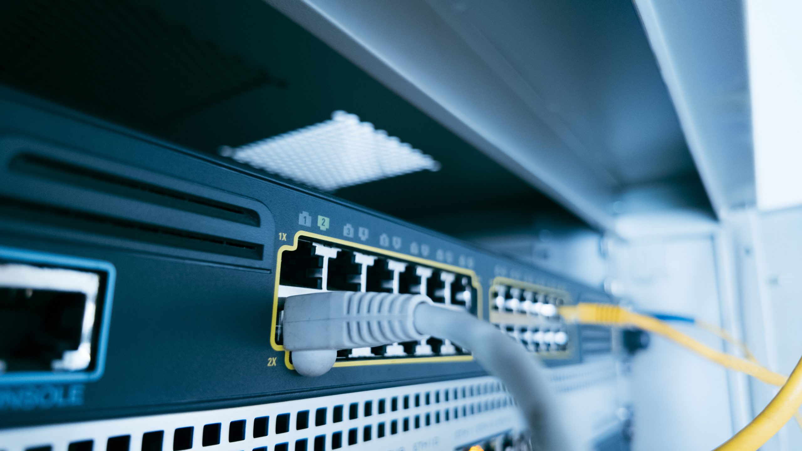 Gray Ethernet cables connected to network equipment, with yellow cables alongside.
